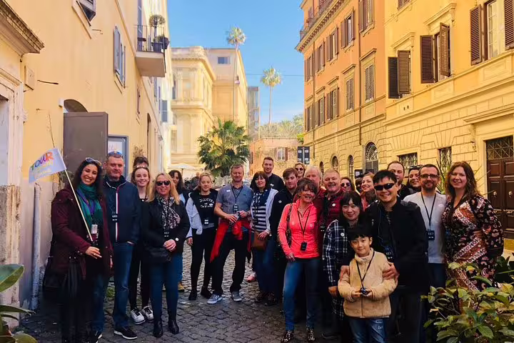 Happy tour group exploring a sunny cobbled street in Rome before visiting the Colosseum, Palatine Hill and Roman Forum