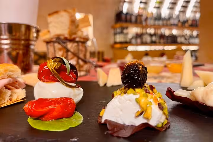 Gourmet Italian appetizers with burrata, pistachios and roasted tomatoes in Trastevere wine bar during Rome food tour