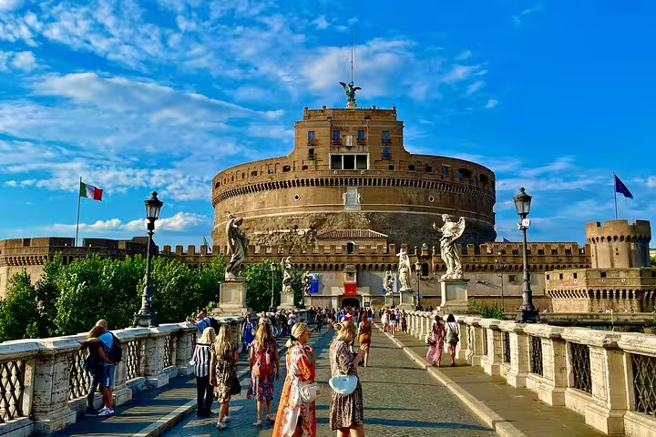 Visitors crossing Ponte Sant’Angelo toward Castel Sant’Angelo on a Rome and Vatican City skip-the-line shore excursion