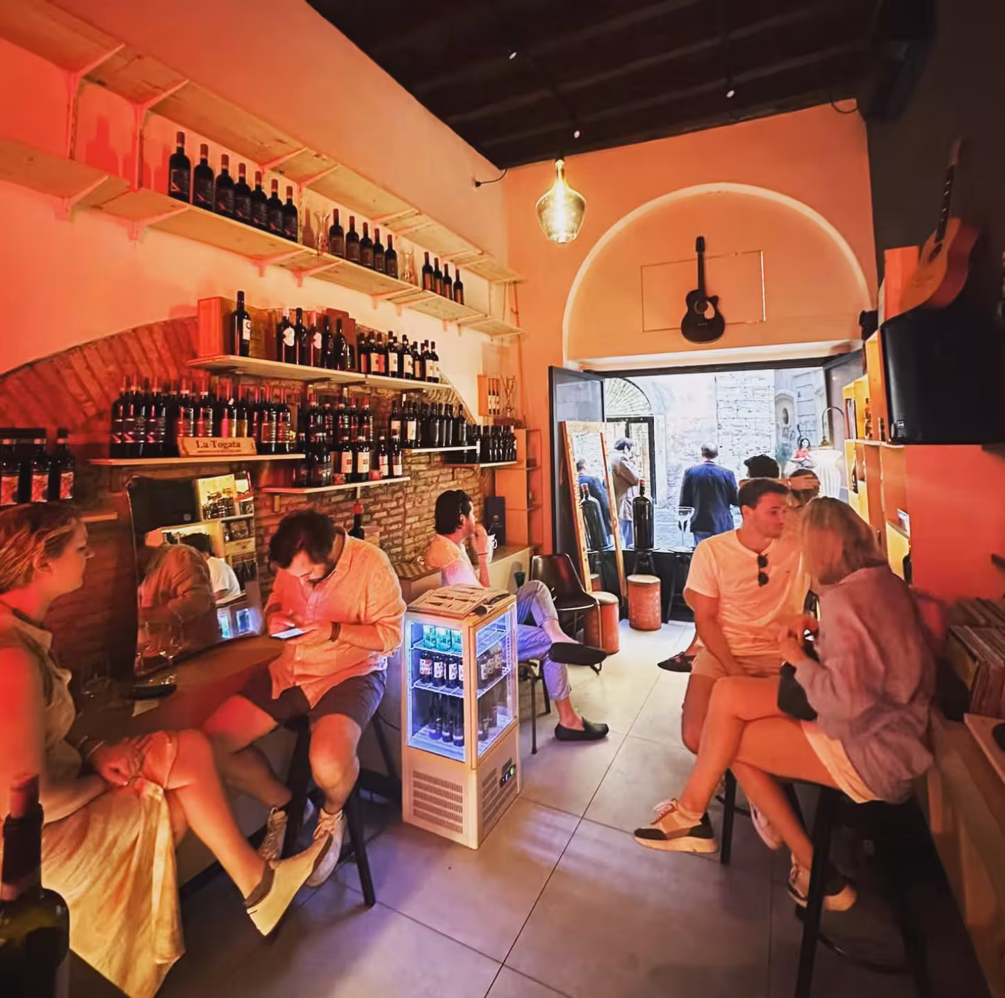 Cozy Rome wine bar interior with shelves of Italian bottles and vinyl ambiance for Wines & Vinyl tour