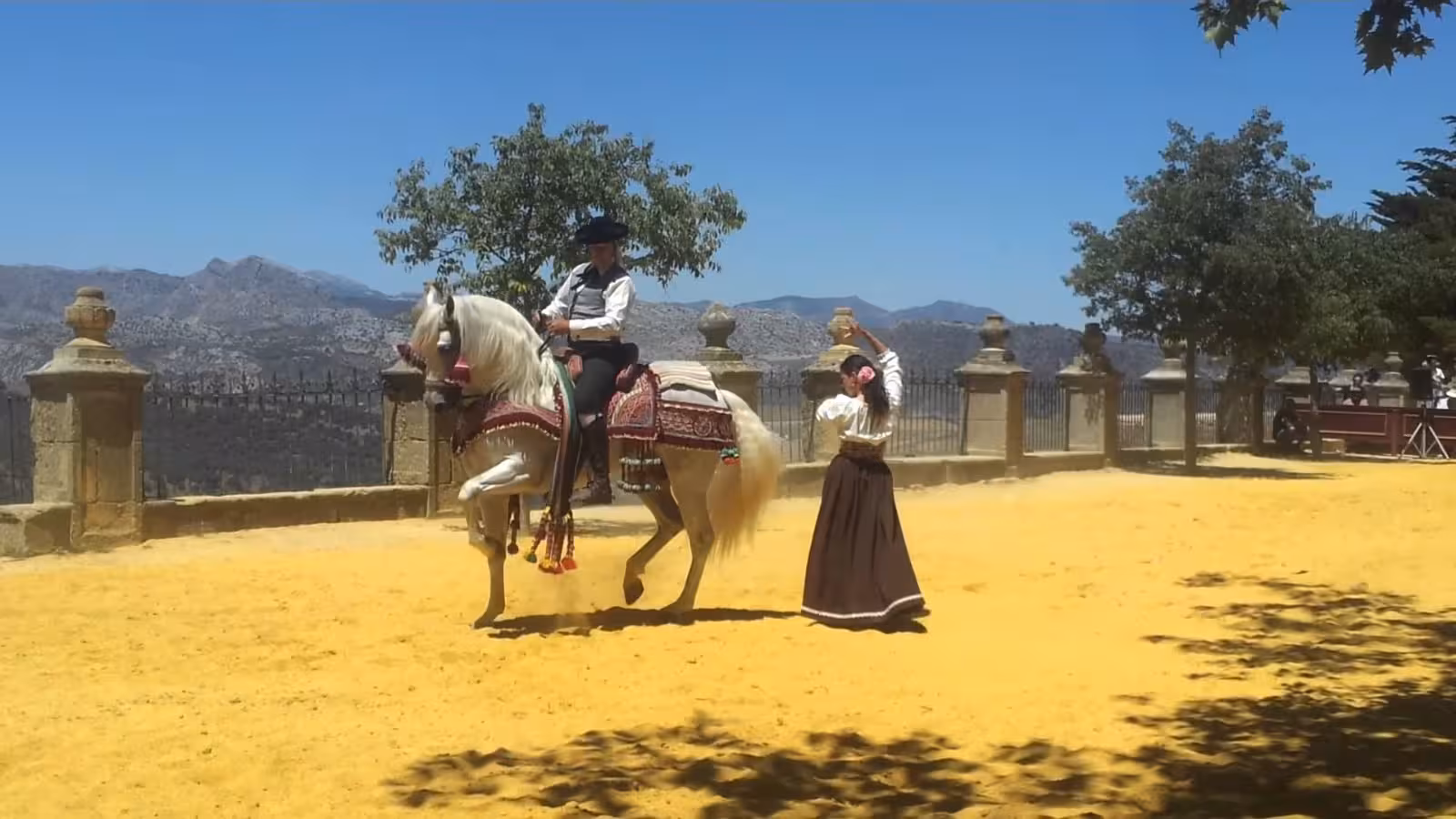 Elegant equestrian display with traditional attire against stunning Ronda mountain backdrop during Ronda Romantica tour.