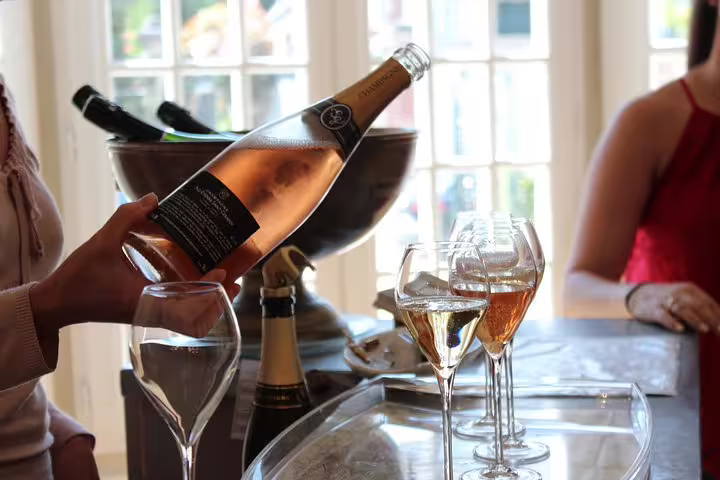 Pouring rosé Champagne into flutes during a guided tasting on a small-group Champagne day tour from Paris