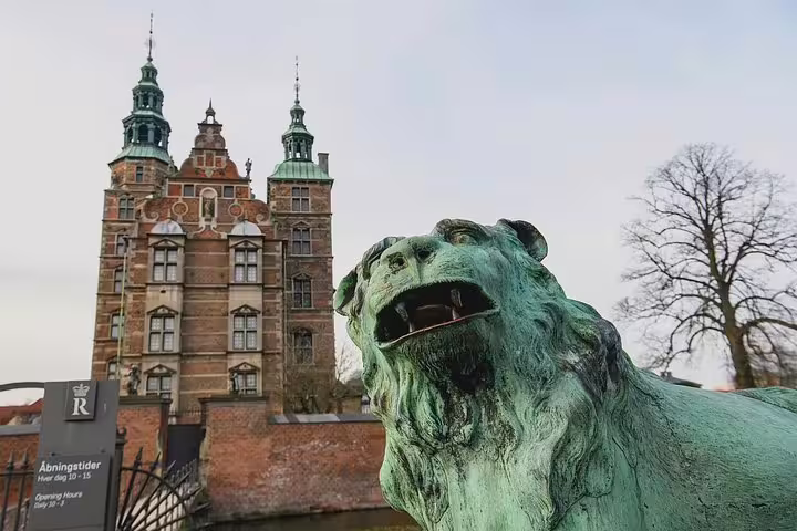 Stunning view of Rosenborg Castle with a majestic lion statue, featured on the Highlights and Secrets of Copenhagen Walking Tour.