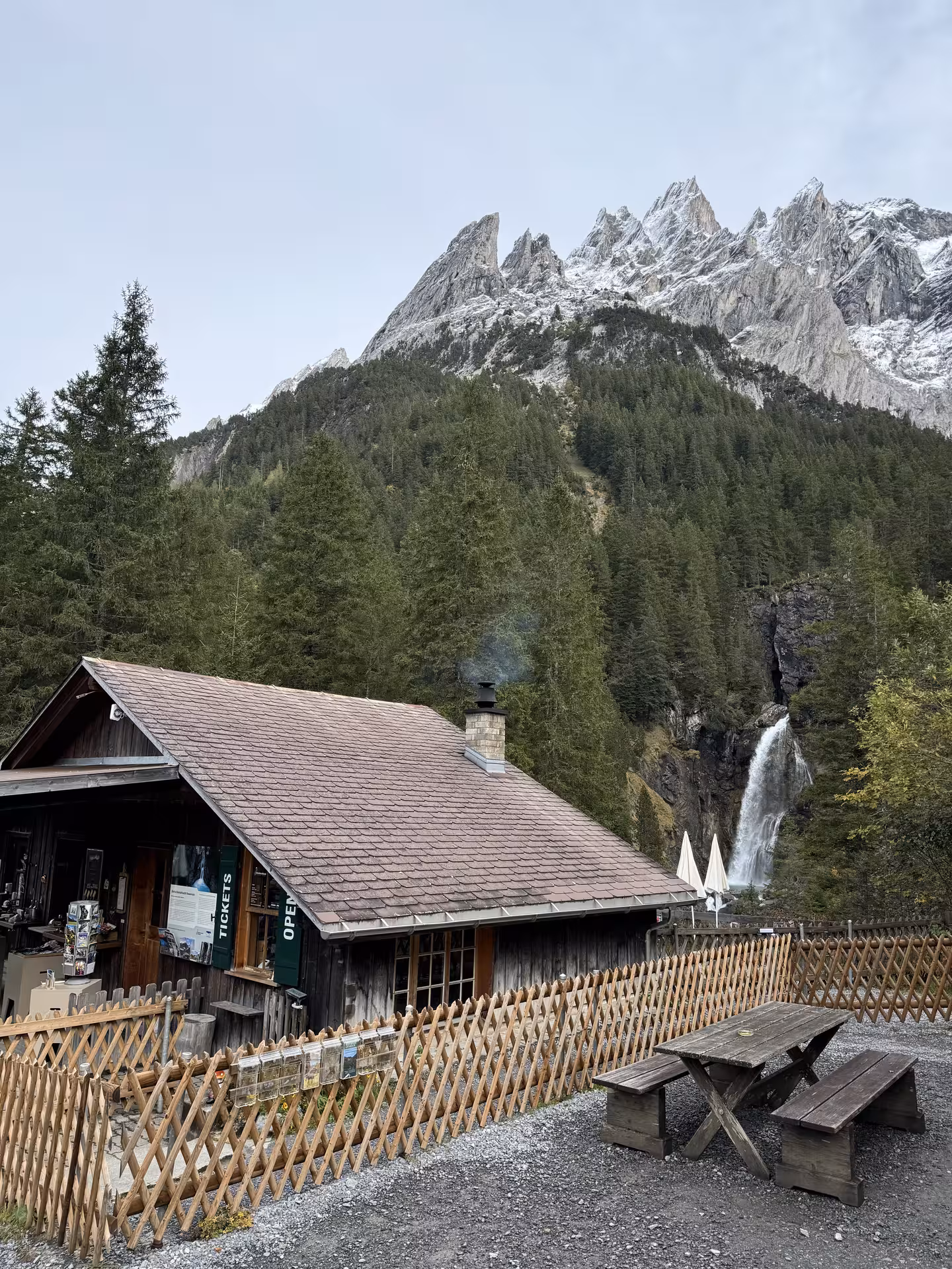 Rosenlaui Gorge ticket hut and waterfall beneath alpine peaks on a Private Rosenlaui Valley e-bike tour