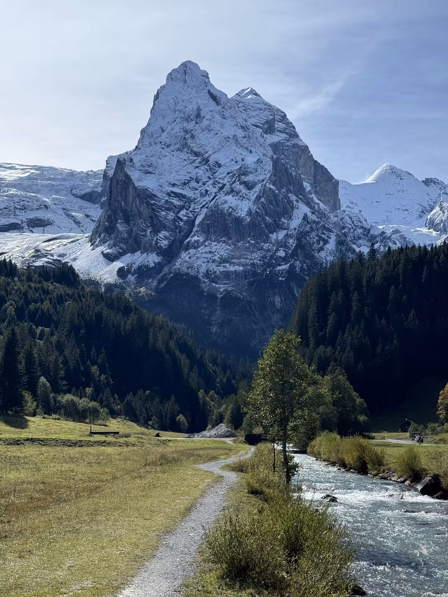 Gravel path and river leading to snowcapped Swiss Alps, panoramic view on Private Rosenlaui Valley e-bike tour