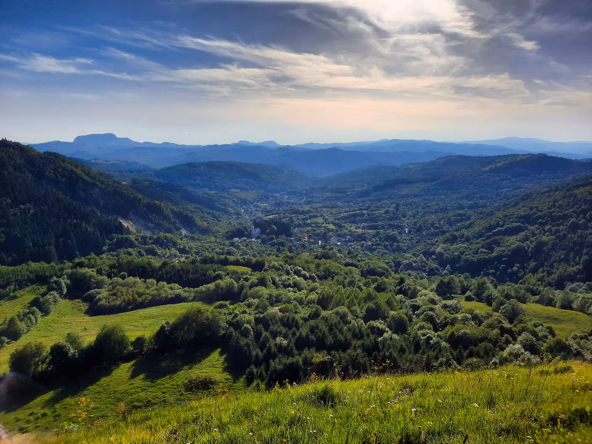 Panoramic valley view of Rosia Montana surrounded by lush green forests and Apuseni Mountains