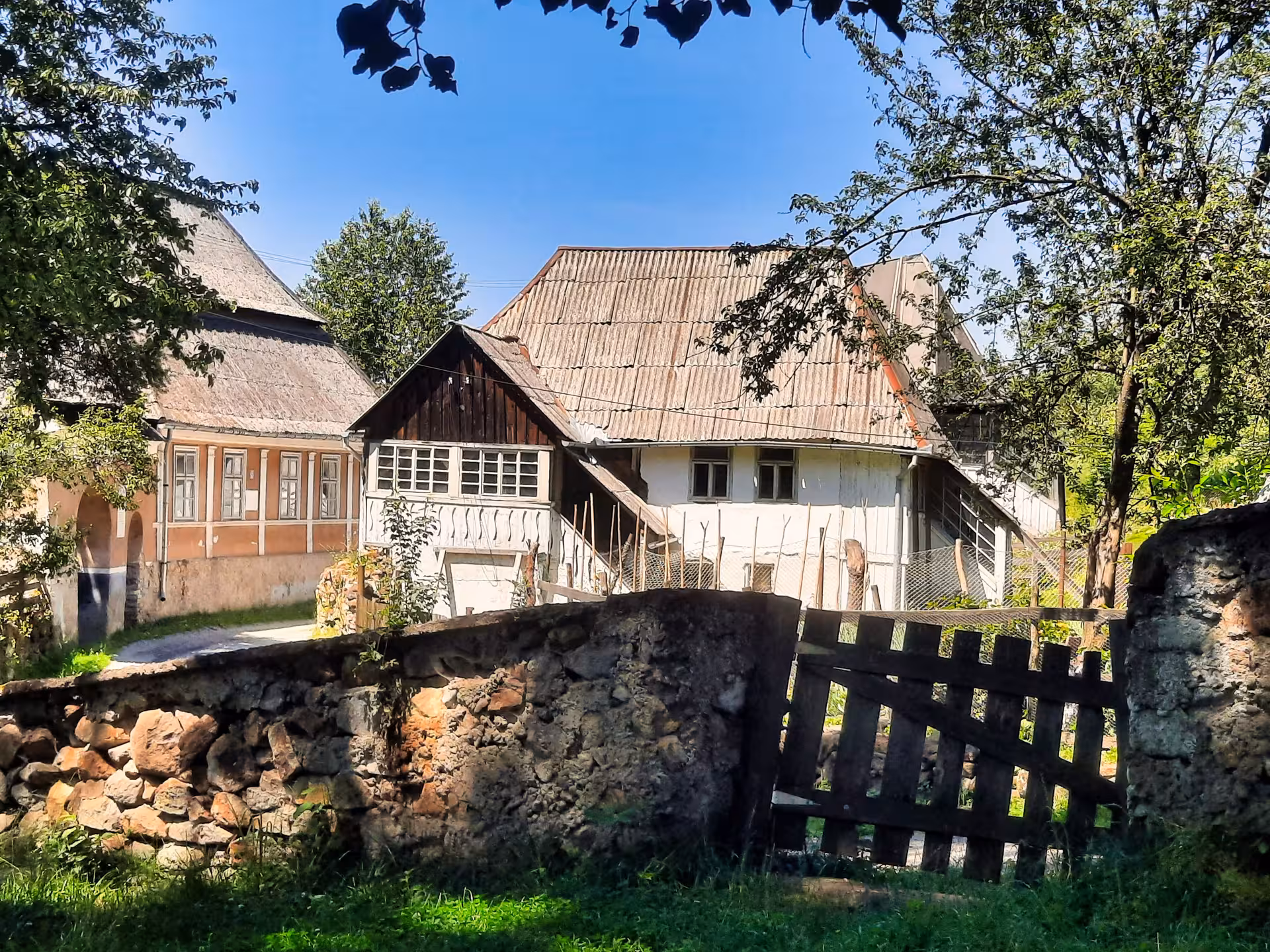 Traditional Saxon village houses with stone wall and wooden gate in Rosia Montana, Apuseni Mountains