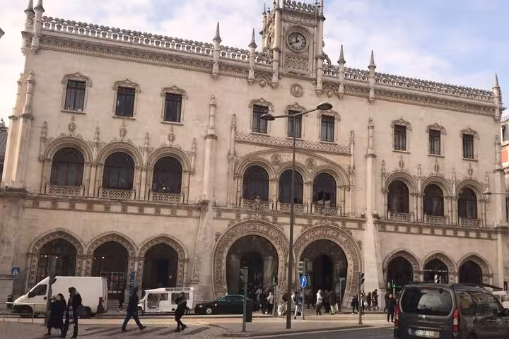 The majestic façade of Rossio Railway Station in Lisbon, showcasing its intricate Neo-Manueline architectural design.