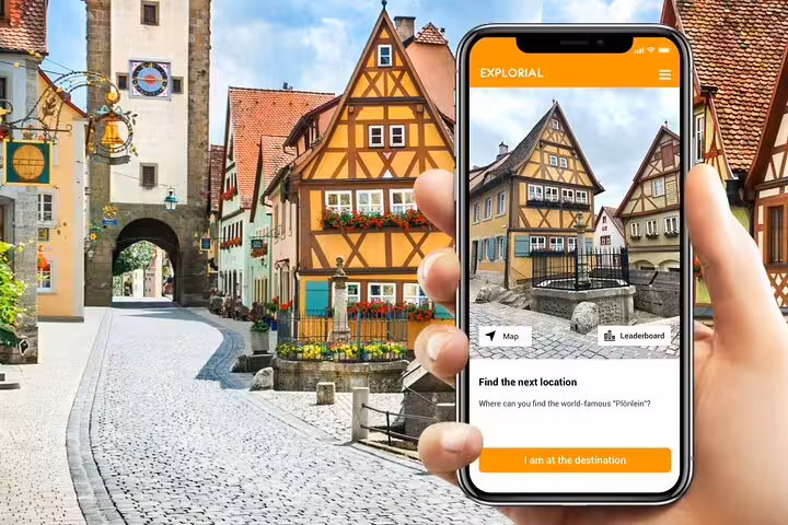 Smartphone app guiding a Rothenburg scavenger hunt tour with Plönlein and medieval old town sights in the background