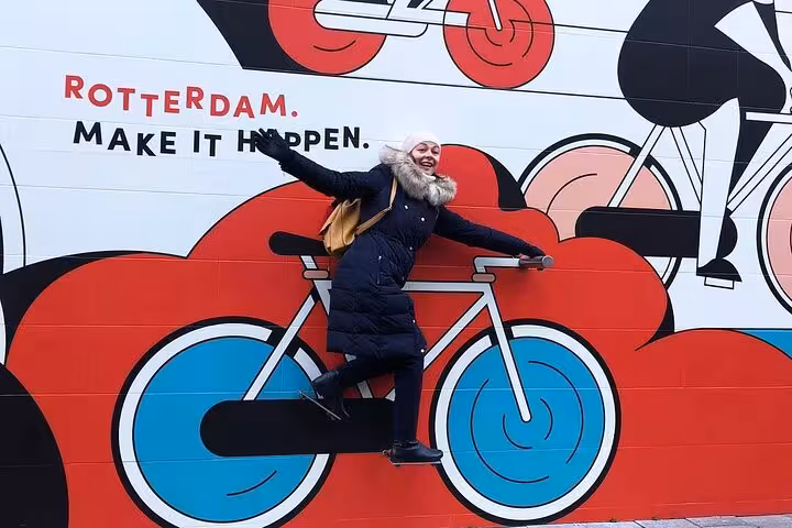 Traveler posing by Rotterdam bike mural street art, fun photo stop on Your Own Holland private sightseeing tour