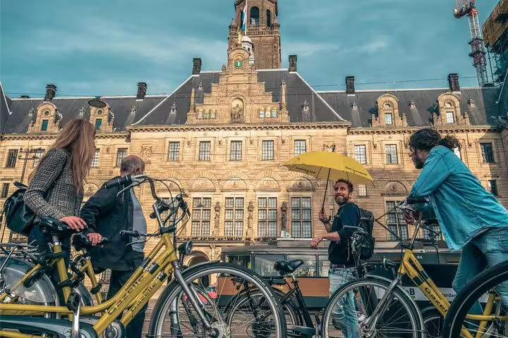 Local guide leads Rotterdam bike tour past City Hall, showcasing classic highlights and skyline views