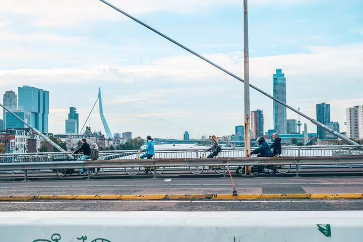 Cyclists crossing Rotterdam’s Erasmus Bridge with skyline views on a classic highlights bike tour with a local