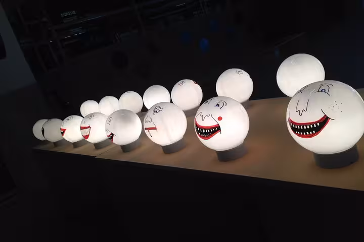 Whimsical illuminated face sculptures at Rotterdam art venue, a quirky stop on a private sightseeing tour