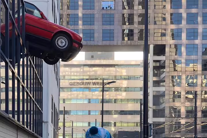 Rotterdam street art walk photo spot with the iconic red car sculpture on a modern building facade downtown
