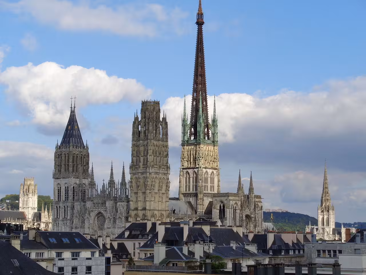 Rouen Cathedral Gothic spires and towers dominating the historic city skyline under blue skies