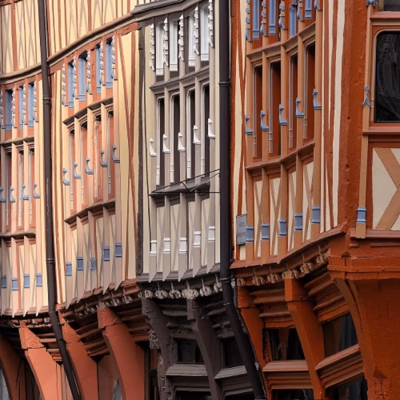 Historic half-timbered medieval facades in Rouen's old town, featuring ornate wooden beams and colorful architecture