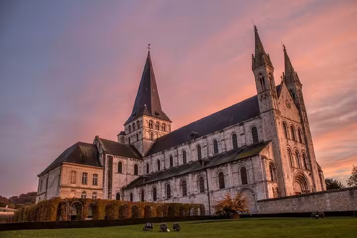 Gothic abbey church with twin spires at sunset, Normandy France