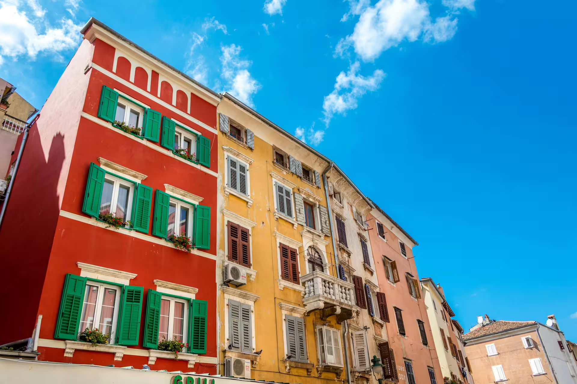 Colorful Rovinj old town facades with shutters under blue sky, highlight of Ancient Istria day trip