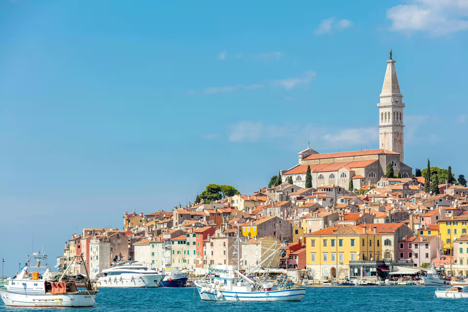Rovinj skyline with St Euphemia Church above waterfront boats, seen on Ancient Istria tour from Poreč