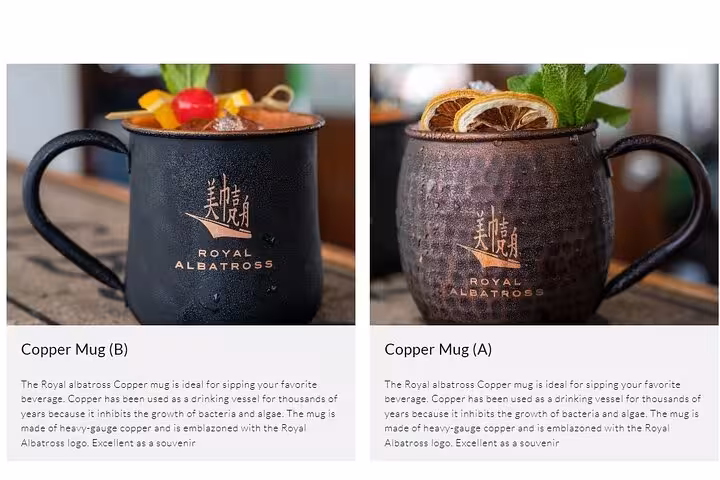 Elegant Royal Albatross copper mugs with fresh garnishes, perfect for a luxurious sunset sail cruise experience.