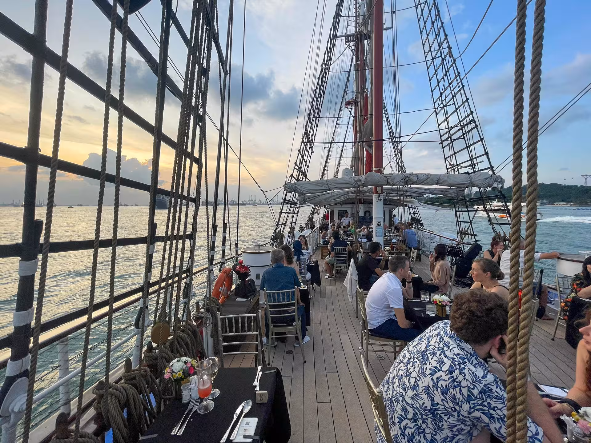 Guests enjoying a sunset sail and seated dinner on the Royal Albatross with stunning ocean and skyline views.