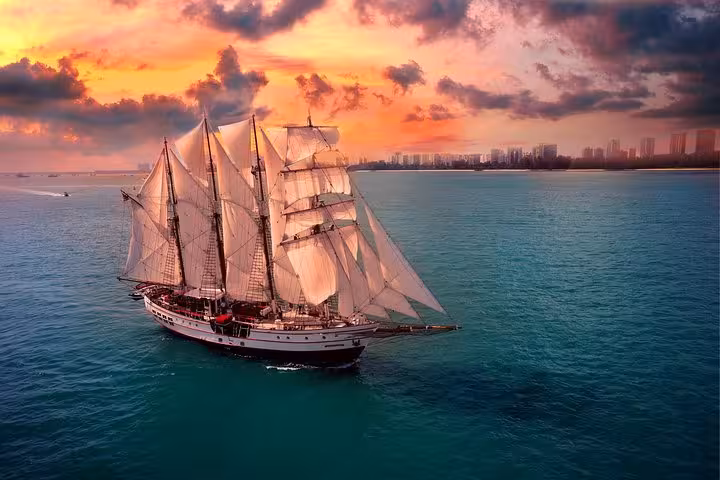 Majestic tall ship Royal Albatross sailing at sunset, offering a scenic 5-course dinner cruise on the open sea.