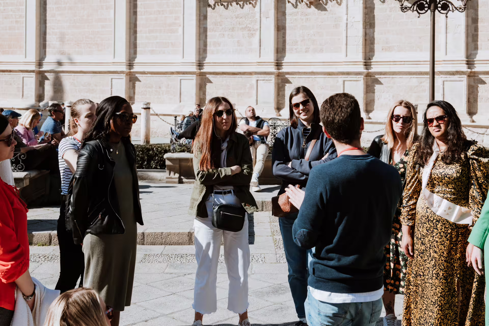 Group of tourists enjoying a guided private tour at the Royal Alcazar of Seville, exploring historic architecture and culture.