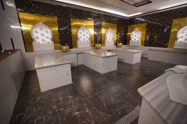 Royal hammam marble treatment benches in Sharm El Sheikh spa, gold accents and relaxing steam bath setting