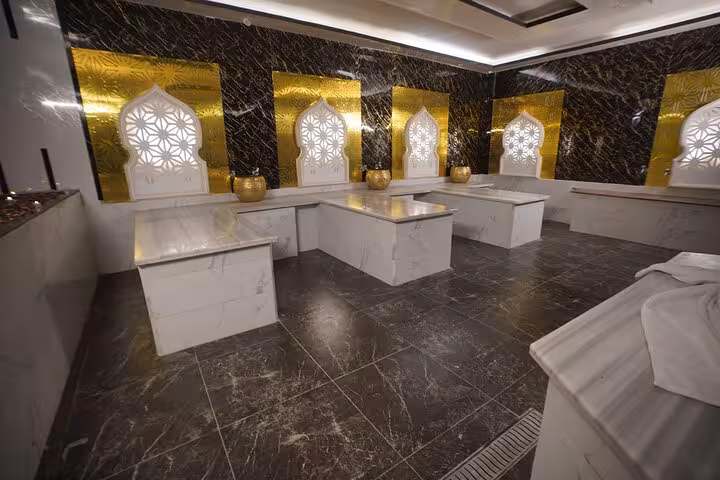 Elegant royal hammam room in Sharm El Sheikh with marble slabs and Moroccan-style arches for spa ritual