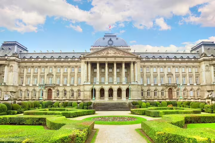 Royal Palace of Brussels with manicured formal gardens and neoclassical facade under blue sky