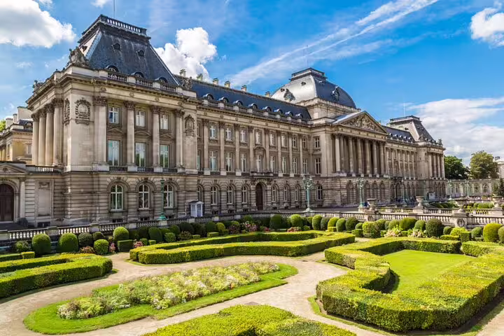 Royal Palace of Brussels with manicured formal gardens under blue sky