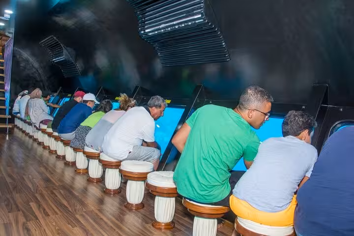 Passengers seated at panoramic windows inside Royal Seascope submarine in Dahab, viewing Red Sea marine life