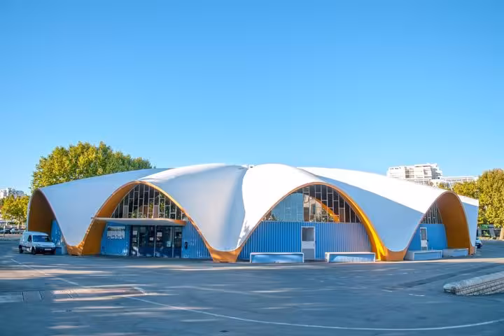Royan market hall with distinctive white arched roof and orange accents under clear blue sky