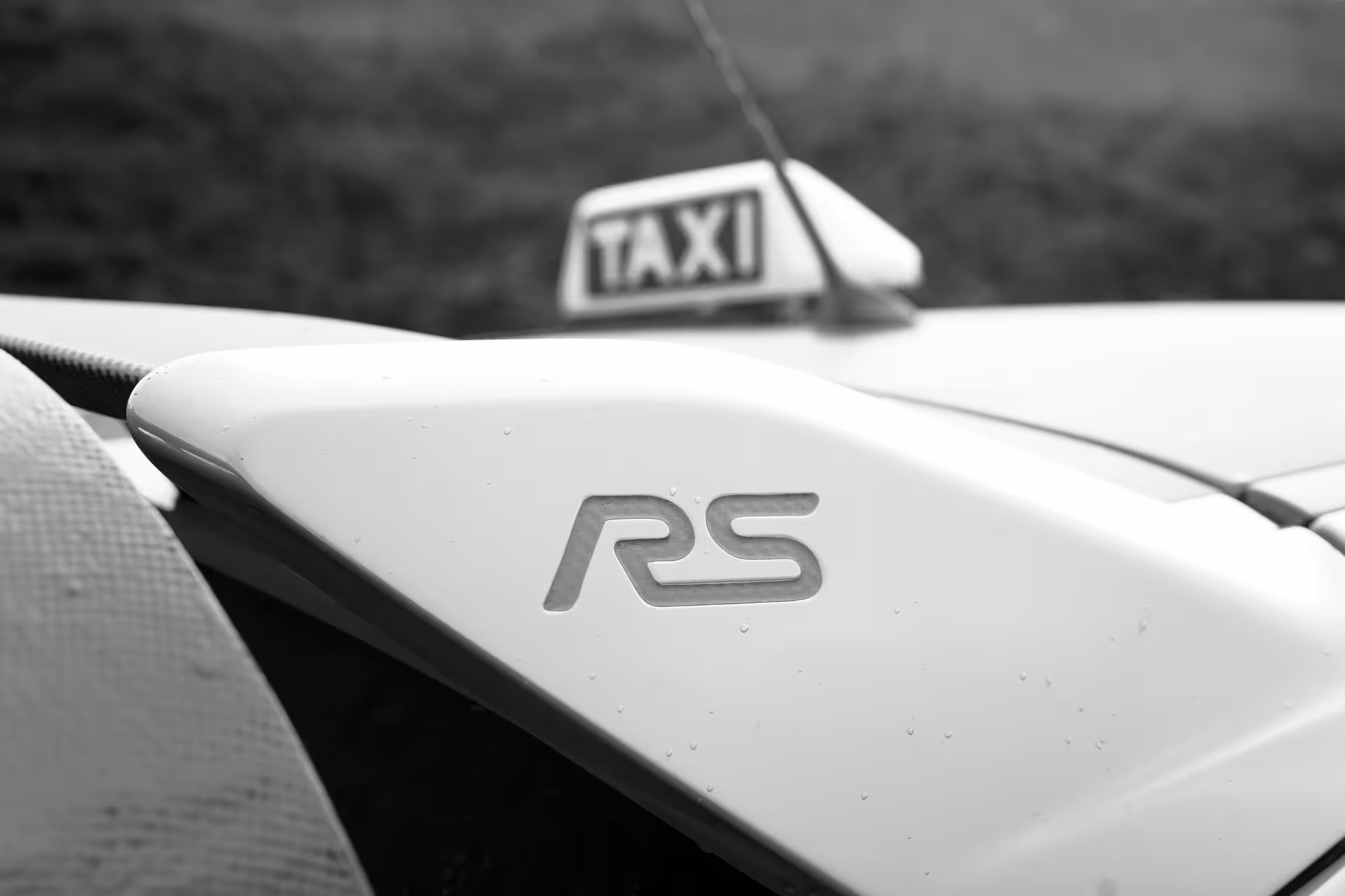Close-up of RS rally car taxi badge for private Keflavik Airport transfer in Iceland, premium pickup