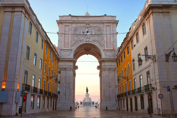 The iconic Rua Augusta Arch in Lisbon at sunrise, showcasing neoclassical architecture on the Highlights and Secrets of Lisbon Tour.