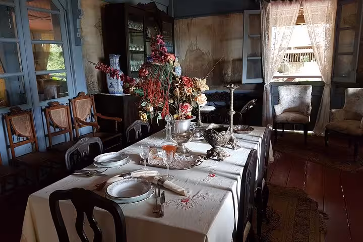 Antique dining room at the Rubber Museum from Manaus tour, with set table, flowers and colonial décor
