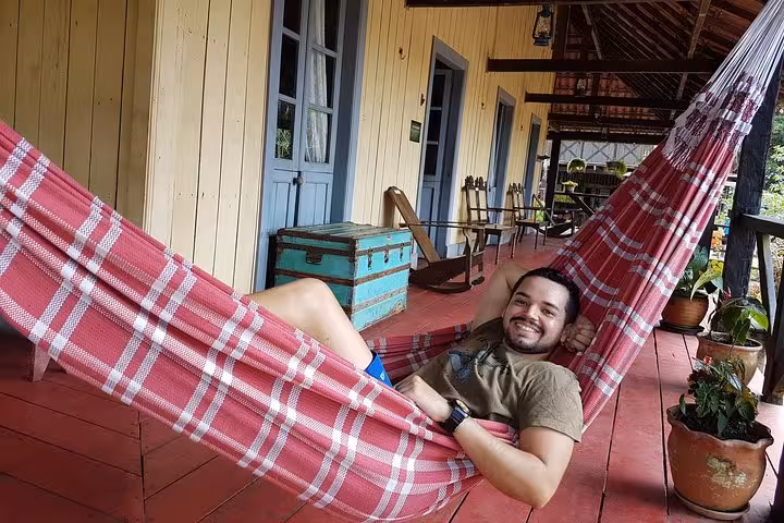 Visitor relaxing in a hammock on the Rubber Museum from Manaus tour, on a historic Amazon rubber plantation porch