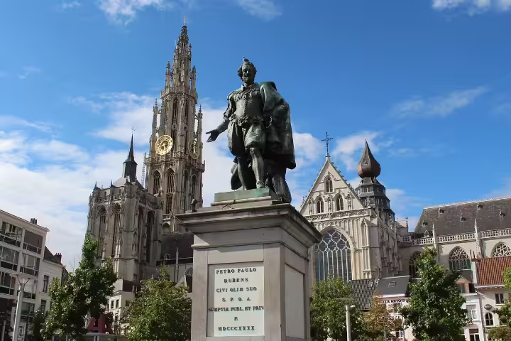 Statue of Peter Paul Rubens in front of the Cathedral of Our Lady on a sunny day, a highlight of Antwerp walking tours.
