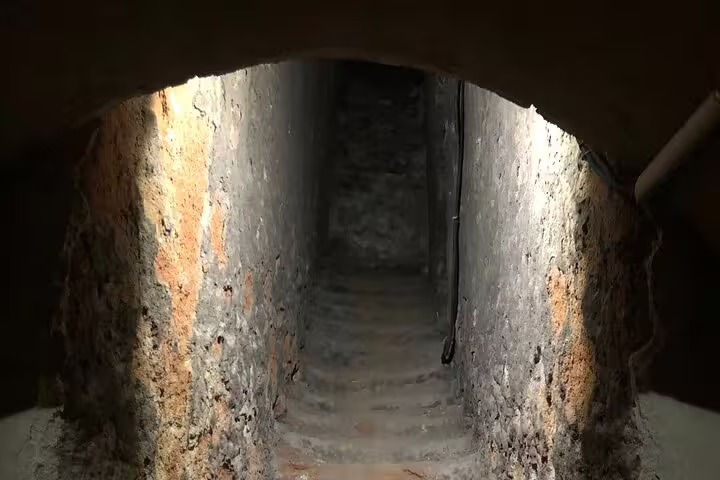 Dimly lit ancient stone staircase in a Rueda wine cellar, part of a Madrid wine tour experience.