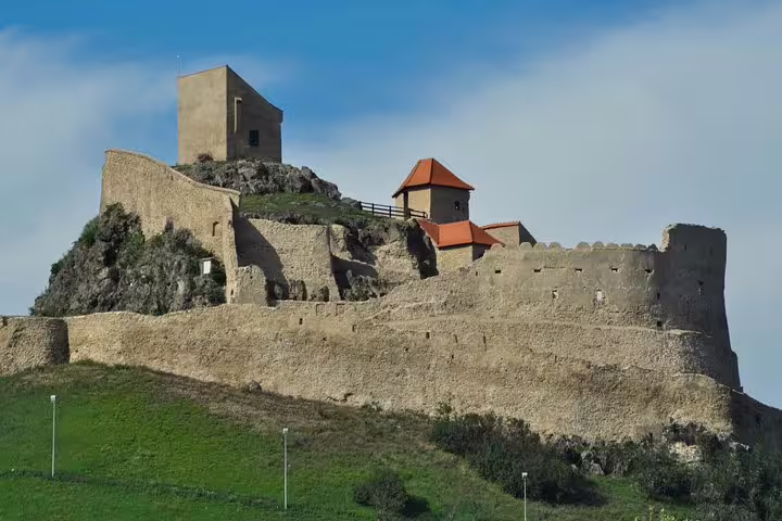 Medieval fortress walls and tower of Rupea Citadel on a rocky hill in Transylvania, Romania