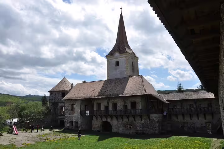 Medieval fortified church with stone walls and pointed steeple at Rupea Fortress, Transylvania, Romania