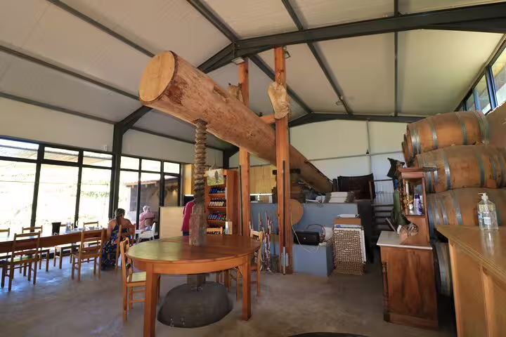 Rustic winery interior with wooden barrels and tables, ideal for half-day jeep wine tour and sea cliff adventure.