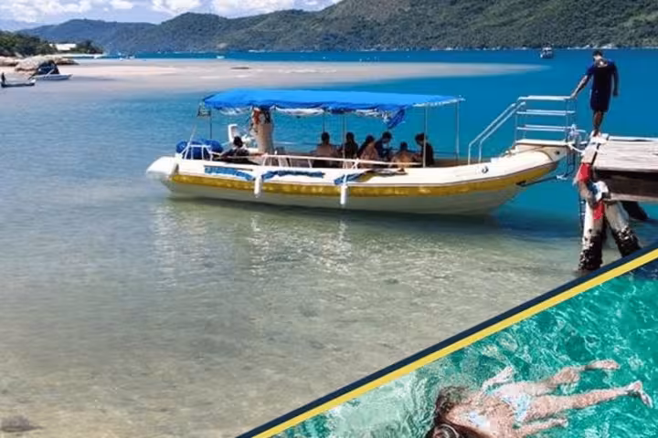 Tourists on a boat exploring the serene beaches and clear waters of Saco Mamanguá Fjord with Paraty Tours.