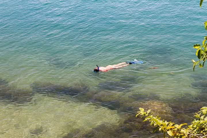 Snorkeler exploring the clear turquoise waters of Saco Mamanguá Fjord, a highlight of the idyllic beach tour.