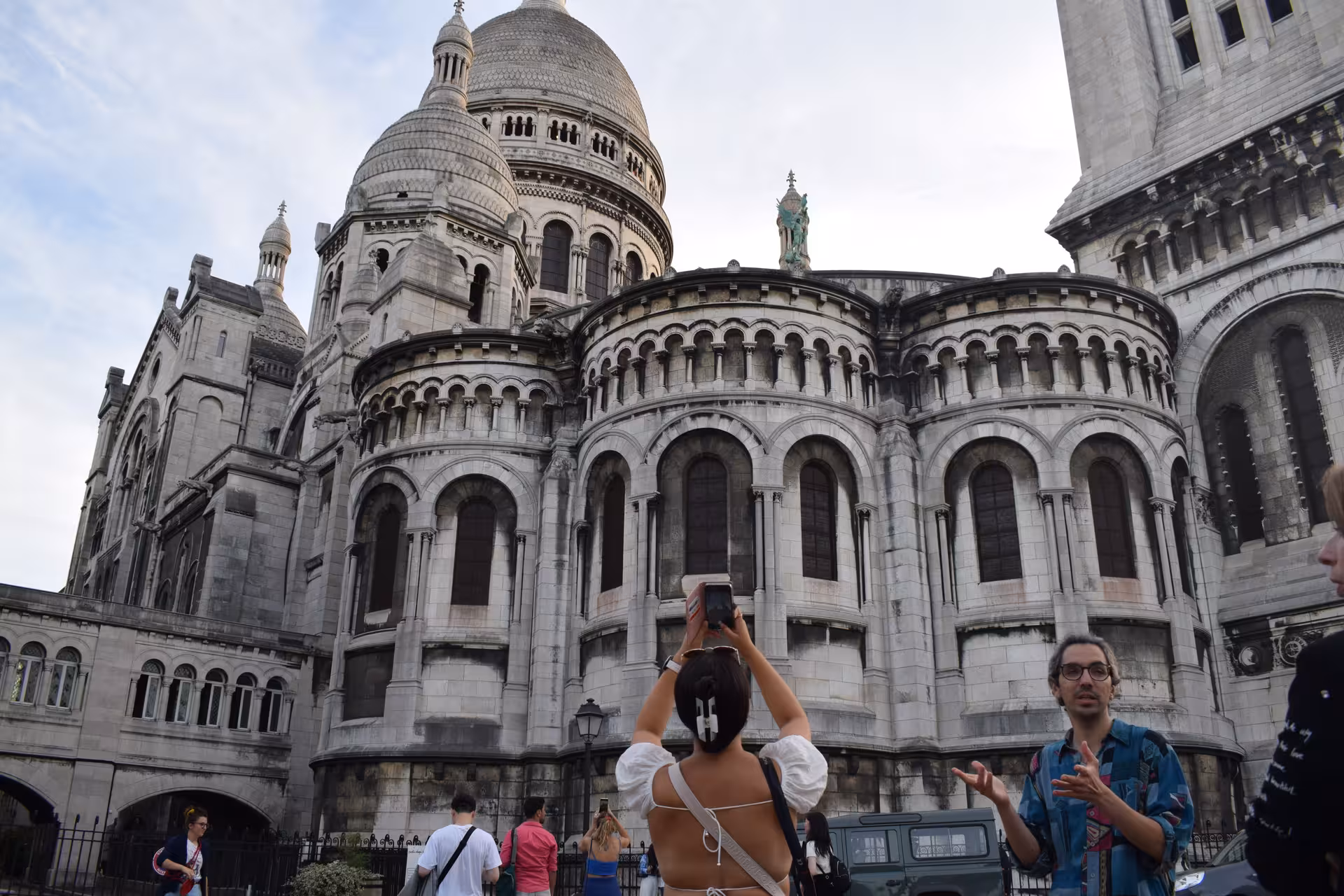 Tourist photographing Sacré-Cœur Basilica from behind in Montmartre, Paris