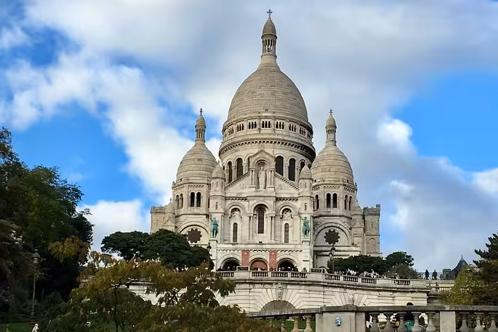 Sacré-Cœur Basilica white domed church on Montmartre hill in Paris under blue sky