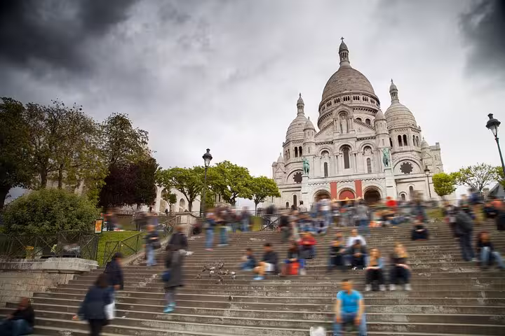 Steps to Sacré-Cœur in Montmartre with crowds, key sight on Paris street art walking tour with French tasting