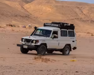 White Toyota Land Cruiser 4x4 jeep driving through sandy desert terrain in Safaga, Egypt