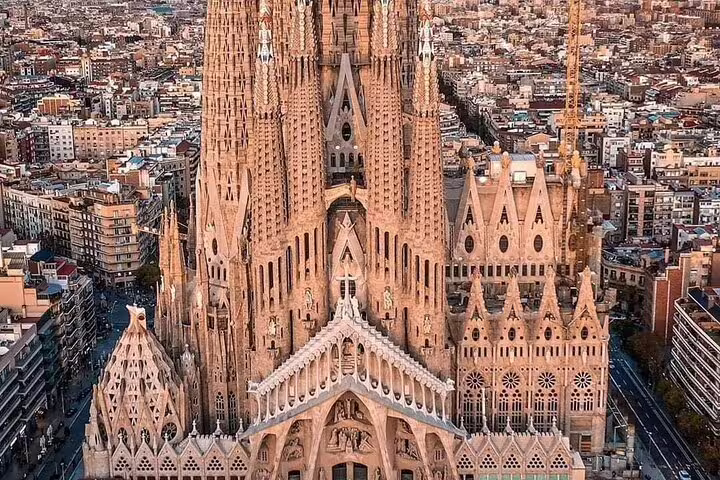Aerial view of Sagrada Família basilica towers and ornate facades rising above Barcelona cityscape