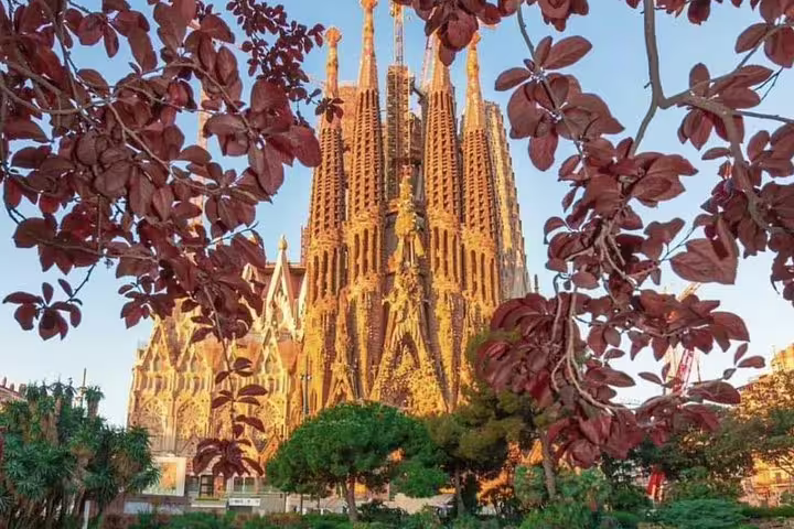 Stunning Sagrada Familia basilica framed by autumn leaves on a full-day private Barcelona Gaudi tour
